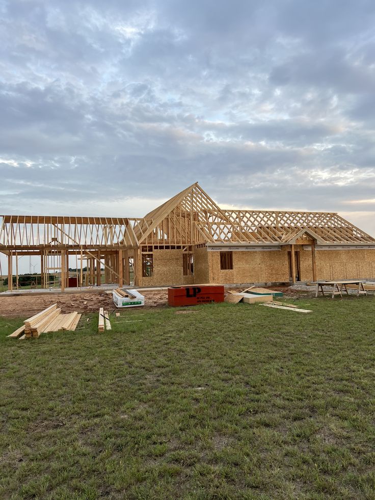 Roof truss framing on a wide single-story build at dusk